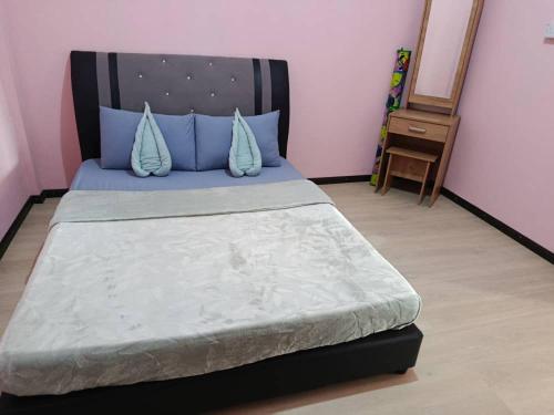 a bedroom with a bed with blue pillows at Dongorit Cabin 2 The three rooms in Kampong Kundassan