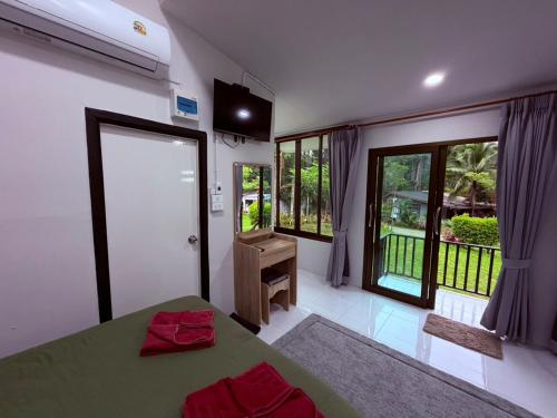 a bedroom with a green bed and a balcony at Khao Sok River Canoe&Resort in Khao Sok National Park