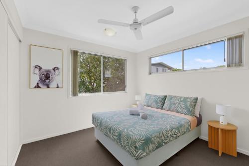 a bedroom with a bed and two windows at Mango Hill 3 Bedroom Family Accommodation in North Lakes