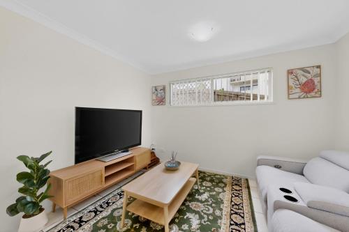a living room with a couch and a tv at Mango Hill 3 Bedroom Family Accommodation in North Lakes