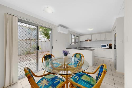 a dining room with a glass table and chairs at Mango Hill 3 Bedroom Family Accommodation in North Lakes