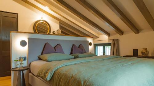 a bedroom with a large bed with purple pillows at Ca Nova Agriturismo in Castellaro