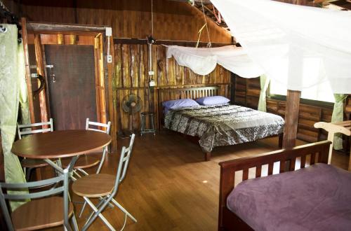 sypialnia z łóżkiem, stołem i krzesłami w obiekcie Sunflower Boathouse w Ko Phi Phi