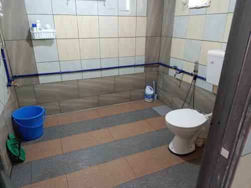 a bathroom with a toilet and a tiled floor at Dongorit Cabin 2 The three rooms in Kampong Kundassan
