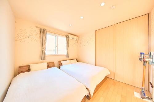 two beds in a small room with a window at Villa Acatella in Awaji