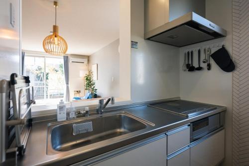 a kitchen with a stainless steel sink and a window at Matsumoto 101 in Matsumoto