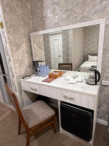 a dressing table with a mirror in a room at HOBIZ Hotel in Navoi