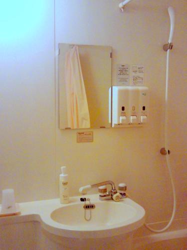 a bathroom with a sink and a mirror at Okaya Central Hotel in Okaya