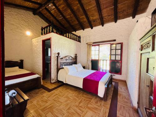 a bedroom with two beds in a room at Posada de Aquilino MC in Cucunubá