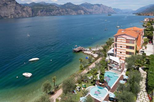 una vista aerea di un resort su un corpo idrico di Belfiore Park Hotel****S a Brenzone sul Garda