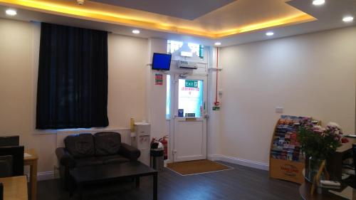 a room with a waiting room with a chair and a door at City View Hotel Stratford in London