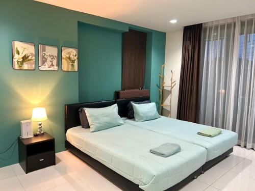 a bedroom with a large bed with blue walls at Serene Panwa beachfront in Ban Ao Makham