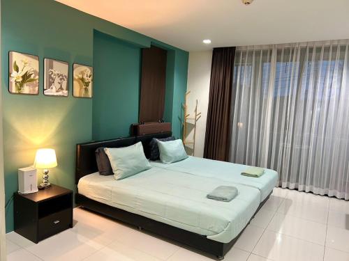 a bedroom with a large bed and a green wall at Serene Panwa beachfront in Ban Ao Makham