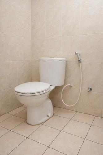 a white toilet in a bathroom with a shower at Mekarsari Hotel By ARBA in Tjipitjung Tiga
