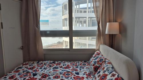 a bed in a room with a window at A house with a beautiful sunset in Ansan