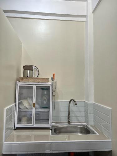 a kitchen with a sink and a microwave at Cardo Rooms 2 minutes walk from the beach in General Luna