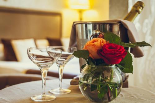 a vase with a rose and two glasses on a table at Di Rienzo Pantheon Palace in Rome