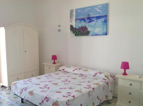 1 dormitorio con 1 cama y una pintura en la pared en Bella Vista en Lipari