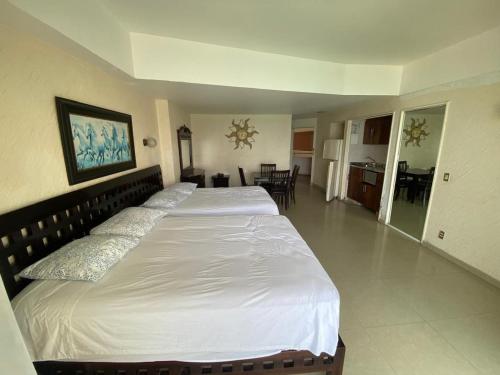 a bedroom with two beds and a living room at Suite en Torres Gemelas Acapulco piso 19 in Acapulco