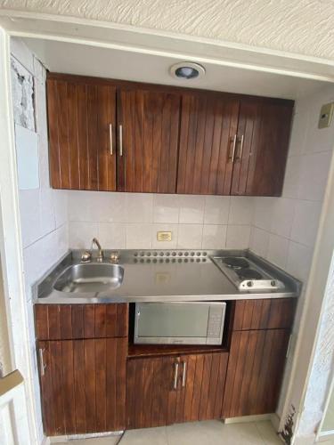a kitchen with wooden cabinets and a sink at Suite en Torres Gemelas Acapulco piso 19 in Acapulco