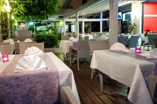 a restaurant with tables and chairs with white tablecloths at Hotel Maritimo in Makarska