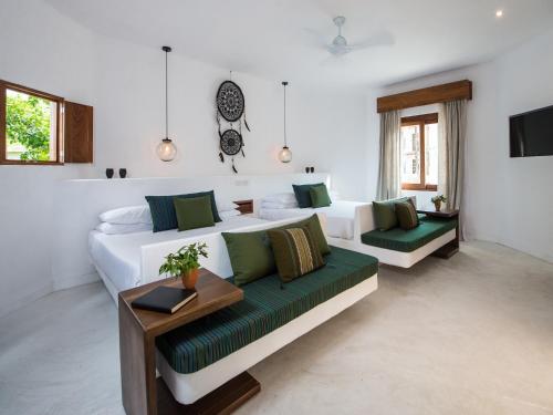 a living room with two beds and a couch at Villas HM Palapas del Mar in Holbox Island