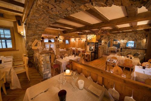 a restaurant with tables and chairs in a building at Hotel Astra in Livigno