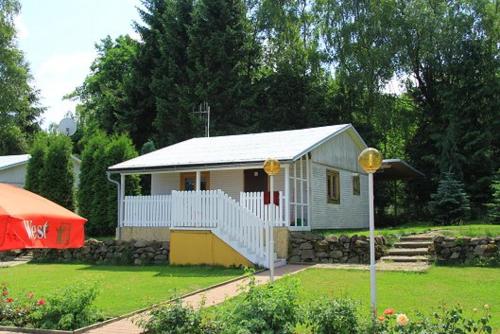 a small white house in a yard with a tent at U Myslivce in Stein Schönau