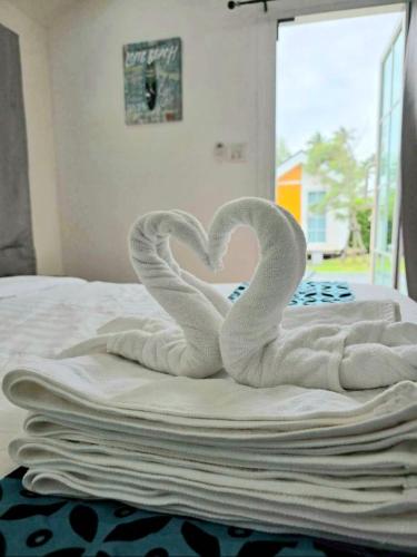two swans making a heart on a bed at บลูคริสตัลรีสอร์ทแหลมสิงห์ in Laem Sing