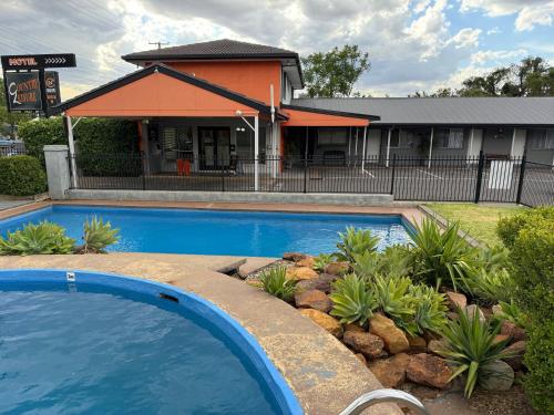 a swimming pool in front of a building at Country Leisure Motor Inn in Dubbo