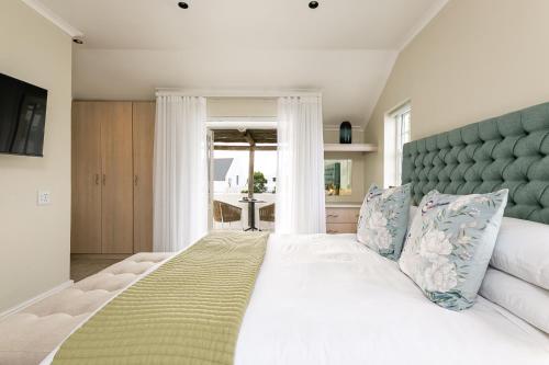 a bedroom with a large white bed with a green headboard at Abalone Hotel & Villas 2 Bedroom Apartment in Paternoster