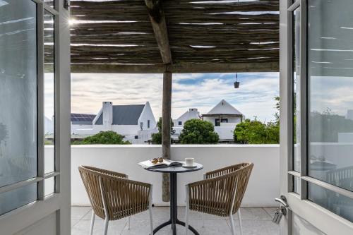 a patio with a table and chairs and windows at Abalone Hotel & Villas 2 Bedroom Apartment in Paternoster