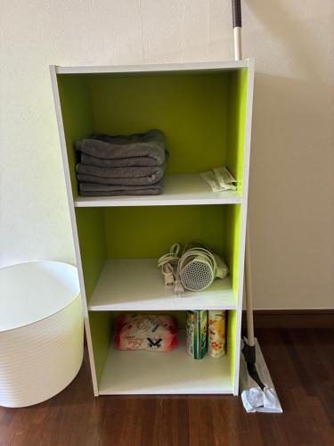 a green shelf with towels and other items on it at アルピエj107号室無料Wi-Fiあり熊本城徒歩5分 in Kami-kumamoto