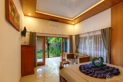 a bedroom with a bed and a living room at Sekumpul Guest House in Sudaji