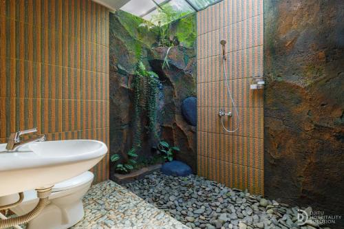 a bathroom with a shower and a toilet and a sink at Sekumpul Guest House in Sudaji