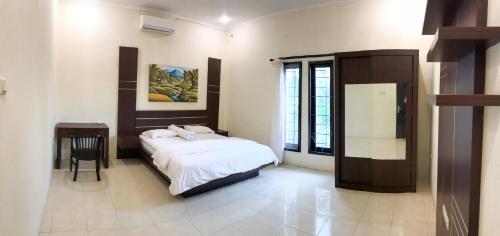 a bedroom with a bed and a table in it at Telaga Villa Siki in Mantaak