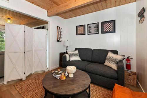 a living room with a couch and a table at Yama Cabin - 5 min walk to the village, EV plug, hot tub, kid & pet friendly in Lake Arrowhead