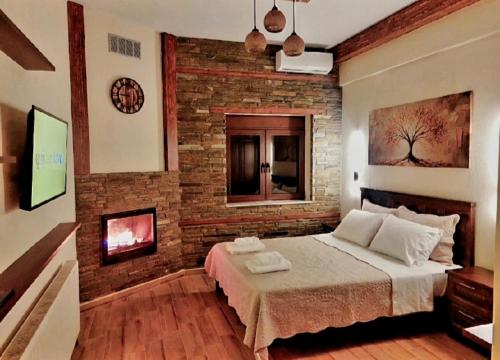 a bedroom with a brick wall and a bed at Petroula Suites Pozar in Kato Loutraki