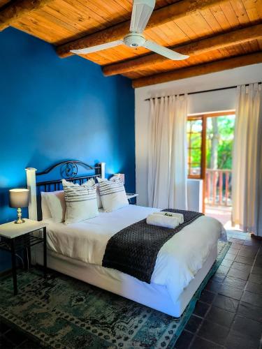 a bedroom with a bed with blue walls and a ceiling at Palm La Vie in Worcester