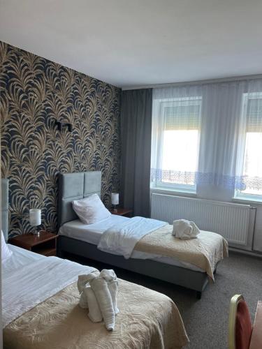 a hotel room with two beds with stuffed animals on them at Hotel Restauracja Twist in Krosno