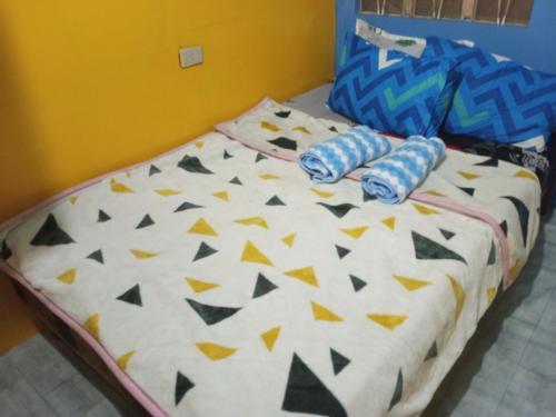 a bed with a comforter with triangles and triangles at iya lee guest hauz in Capissayan
