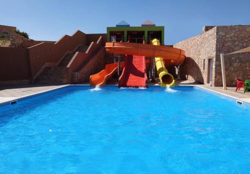 a water slide in a swimming pool at Vai by Romance Hotel & Aqua Park in Ain Sokhna