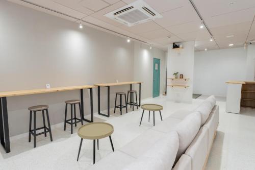 a living room with a couch and bar stools at atic Guesthouse in Takamatsu
