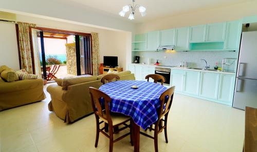 a kitchen and living room with a table and chairs at Krinakia Villas in Xerokampos