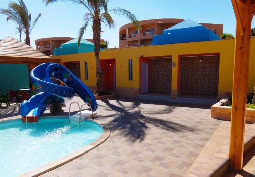 a pool with a blue slide in front of a building at Vai by Romance Hotel & Aqua Park in Ain Sokhna