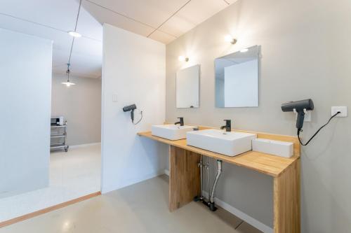 a bathroom with two sinks and a mirror at atic Guesthouse in Takamatsu