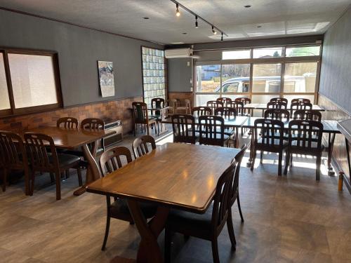 a dining room with wooden tables and chairs at HOTEL MtFuji MOMO AUNG 桃庵 in Yamanakako