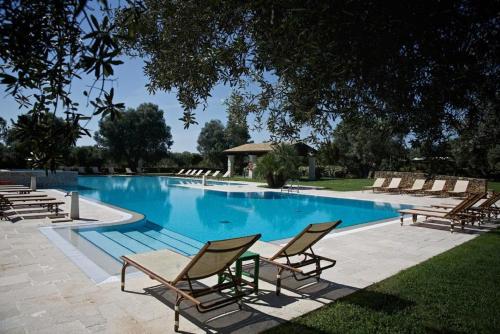 a swimming pool with chaise lounges and chairs around it at Tenuta Monacelli Lecce in Lecce