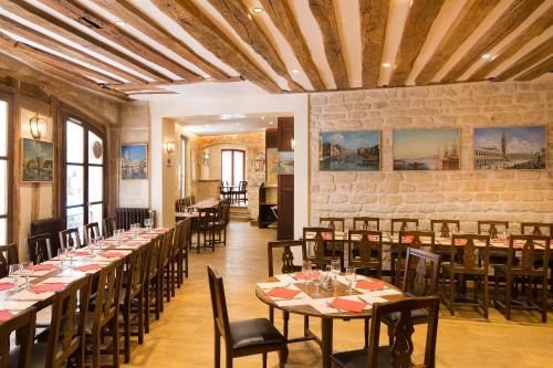 une salle à manger avec de longues tables et des chaises dans l'établissement Europe Saint Severin-Paris Notre Dame, à Paris