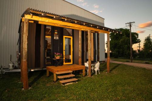 a pavilion with a bench in the grass next to a building at The Orchard View by Tiny Away in Nashdale